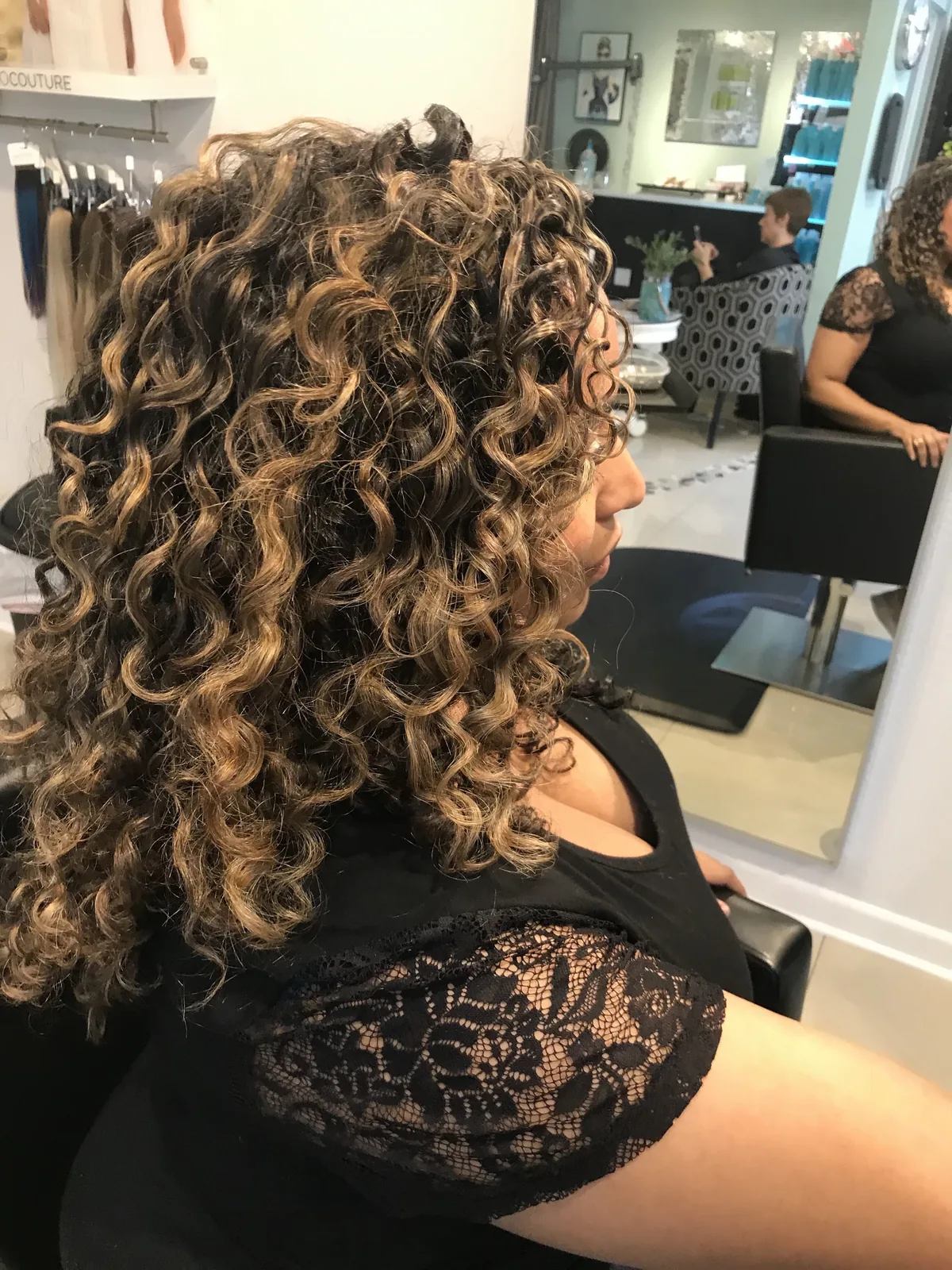 Deva cut with golden highlights on tight spiral curls, overhead view by Richie at Damron & Company Salon in Austin
