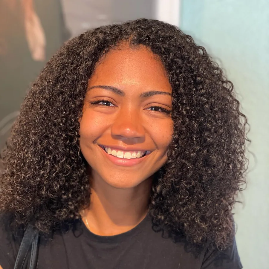Deva cut with hydrating deep conditioner on dense shoulder-length tight coils, smiling client by Richie at Damron & Company Salon in Austin