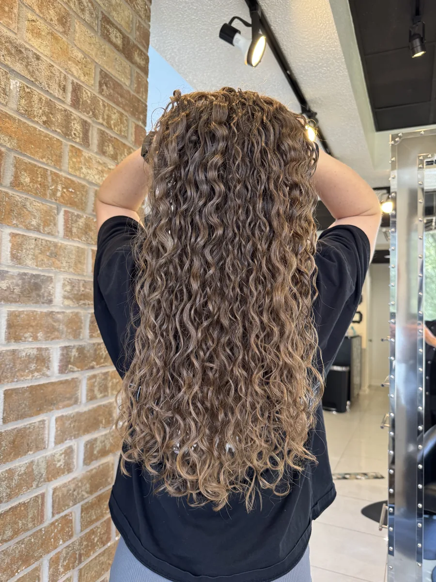 Deva cut on long flowing waves, back view by Richie at Damron & Company Salon in Austin