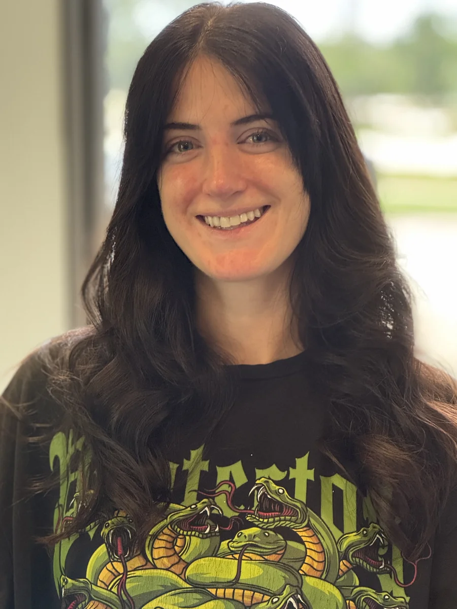 Long layered haircut with soft styled waves on dark hair, smiling client by Richie at Damron & Company Salon in Austin