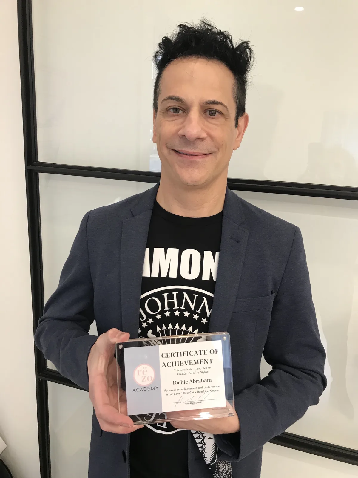 Richie holding his Rëzo Academy RëzoCut certification, Level 1 RëzoCut + RëzoLites